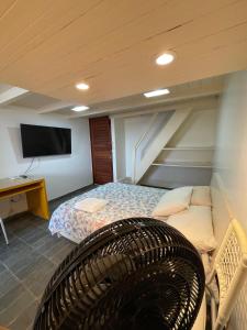 a room with a bed and a tv and a couch at CONDOMÍNIO IMPERIAL, PRAIA DO FRANCÊS in Praia do Frances