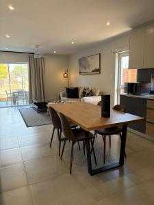 a kitchen and living room with a wooden table and chairs at SixtyOneAt1- George Central in George
