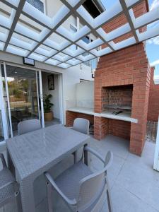a patio with a table and a brick fireplace at SixtyOneAt1- George Central in George