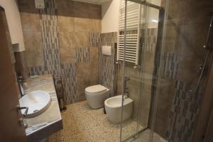 a bathroom with a toilet and a sink and a shower at Casa Dante in Vitorchiano