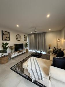 a large living room with a couch and a tv at SixtyOneAt1- George Central in George