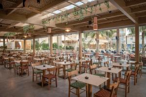 a restaurant with tables and chairs in a room at Enorme Infinity Beach ex Infinity Blue in Hersonissos +116 photos