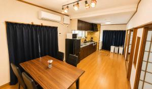 a kitchen and dining room with a table in a room at 姫路駅から徒歩4分 最大13名に貸し切り一軒家 先姫亭 in Himeji