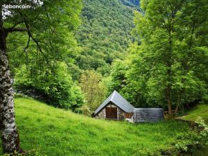 a small cabin on the side of a grassy hill at la Petite Grange Escouaraou in Melles