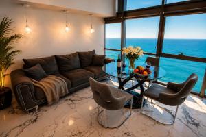 a living room with a couch and a glass table at Penthouse Panorama Luxury Sea View Premium Stay in Batumi in Batumi
