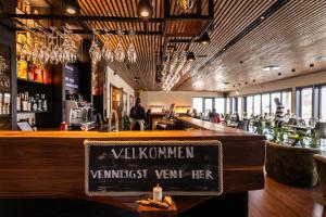 a bar in a restaurant with a sign on the counter at Rosenlund Hamn in Sande