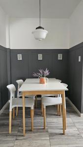 a dining room with a white table and chairs at En Espejo in Mendoza