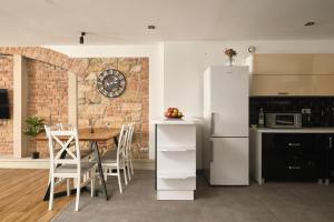 a kitchen with a refrigerator and a table with chairs at Apartament Gold 2 in Złotoryja