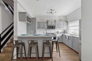 a kitchen with white cabinets and bar stools at Arcadian Place in Port-of-Spain +20 photos