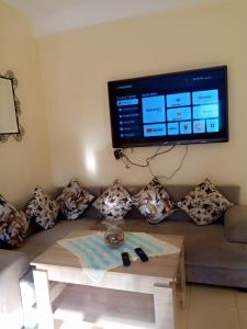 a living room with a couch with a tv on the wall at Irini in Ifrane