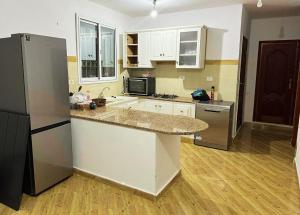 a kitchen with a counter top and a refrigerator at Villa Sounine Rafraf in Bizerte