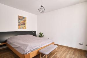 a bedroom with a bed and a chair at Apartament Gold 2 in Złotoryja