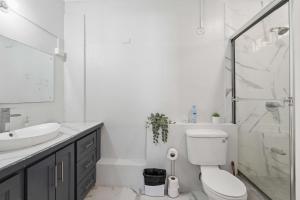 a bathroom with a shower and a toilet and a sink at Arcadian Place in Port-of-Spain