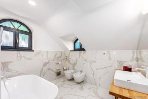 a white bathroom with two toilets and a sink at Dokia Boutique in Gura Humorului +25 photos