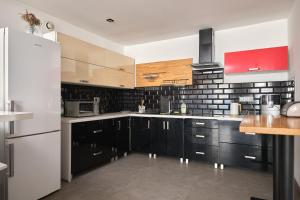 a kitchen with black cabinets and a white refrigerator at Apartament Gold 2 in Złotoryja +1 photo