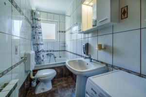 a white bathroom with a sink and a toilet at Apartments Anka in Krk