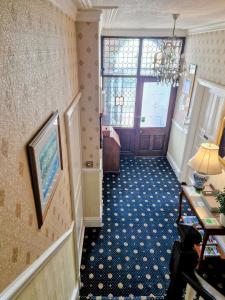 a hallway with a room with a door and a table at Crescent Lodge Guest House in Whitby +7 photos