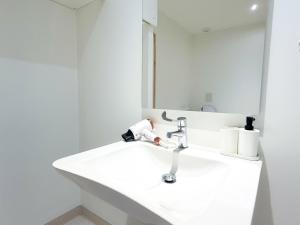 a white bathroom with a sink and a mirror at Volcania Suites in Clermont-Ferrand +110 photos