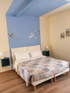 a bedroom with a large bed in a room with blue ceilings at Sleep & Fly Villa Ornella in Case Nuove
