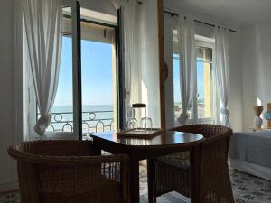 a dining room with a table and chairs and a balcony at Le Petit Café L'arriere Cour in Cancale