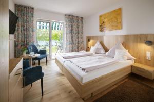a hotel room with a large bed and a desk at Iris am See garni in Radolfzell am Bodensee
