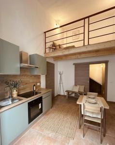 a kitchen with a table and a kitchen with a loft at Be Local-Avola stay in Avola