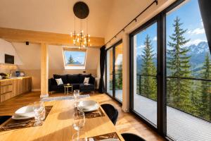 a living room with a table and chairs and mountains at Tatry Residence SPA in Kościelisko