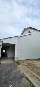 a large white building with a large garage at 姫路駅から徒歩4分 最大13名に貸し切り一軒家 先姫亭 in Himeji