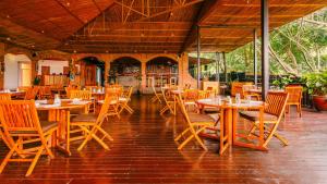an empty restaurant with wooden tables and chairs at Heaven Boutique Hotel in Kigali