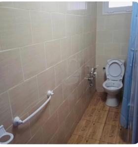 a bathroom with a toilet with a blue shower curtain at Villa Sounine Rafraf in Bizerte +35 photos