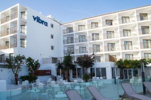 a hotel with chairs and tables in front of a building at Hotel Vibra San Remo in San Antonio Bay
