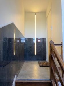 a bathroom with a shower with black tiles at Le Cygne 2eme etage in Avranches +16 photos