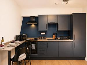 a kitchen with gray cabinets and a table with chairs at Flat 7 in central Bromley - underground parking in Bromley +6 photos