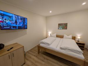 a bedroom with a bed and a tv on the wall at Landhotel Biberburg in Bad Liebenwerda