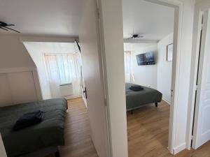 a room with a bed and a couch and a window at Le Cygne 2eme etage in Avranches