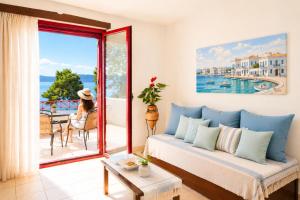 a living room with a couch and a window at Makis Inn Resort in Thermisía