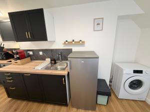 a kitchen with a sink and a washing machine at Le Cygne 2eme etage in Avranches