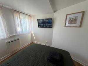 a bedroom with a bed and a window at Le Cygne 2eme etage in Avranches