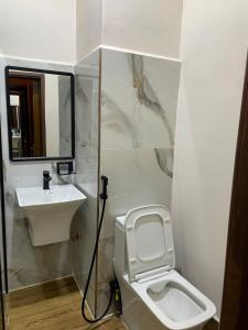 a bathroom with a toilet and a sink at Peak Park Hotel in Mbeya
