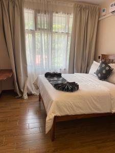 a bedroom with a bed and a large window at Peak Park Hotel in Mbeya