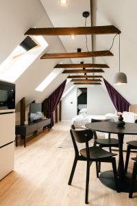 a living room with a dining room table and a kitchen at Flowers House Sibiu in Sibiu