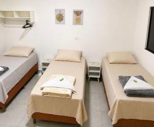 a room with two beds with towels on them at Hotel Catedral in Ribas do Rio Pardo