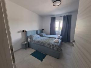 a small bedroom with a bed and a window at Apartman Tea in Pićan