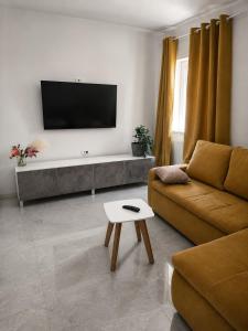 a living room with a couch and a tv at Apartman Tea in Pićan