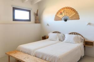two beds in a room with a table and a window at Finca Son Vidal in Llucmajor