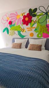 a bedroom with a bed with flowers on the wall at Les Chambres des Lisières d'Havré - Chambres d'hôtes in Mons