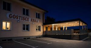 a building with a parking lot in front of it at Gostišče Krka in Znojile pri Krki