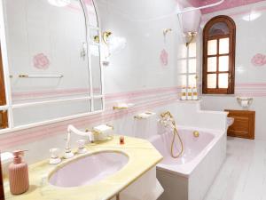 a white bathroom with a sink and a tub at Torre Florio in Campofelice di Roccella