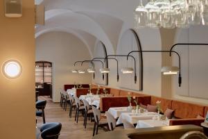 a dining room with white tables and chairs and chandeliers at Hotel Palais Mailberger Hof in Vienna
