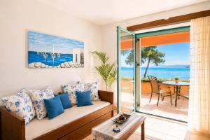 a living room with a couch and a view of the ocean at Makis Inn Resort in Thermisía